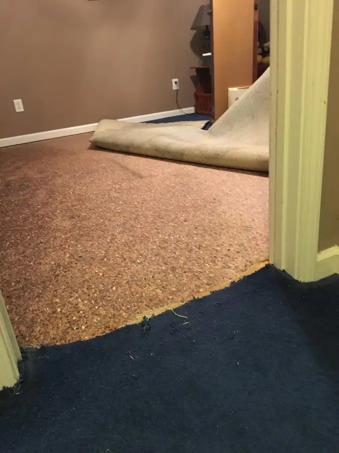 Carpet pad removal revealing water damage during Water Mitigation Services in Smyrna